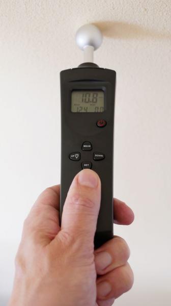 Moisture analyser CD-100 in the hand on the wall